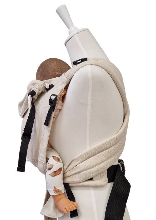 Storchenwiege Talemo Herringbone draagzak in lichtbeige, zijaanzicht met baby en zwarte gespen