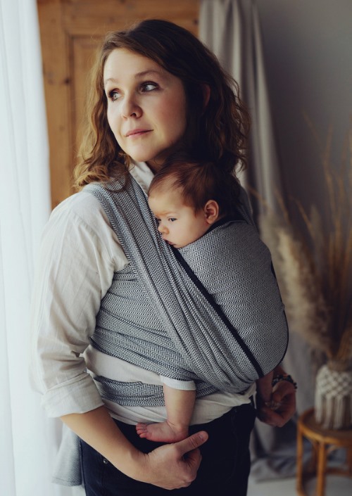 Moeder draagt baby in grijs visgraatpatroon Little Frog Zen Path draagdoek