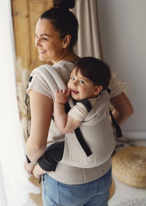 Beige Little Frog Swift Toddler Carrier met peuter op de rug gedragen door vrouw