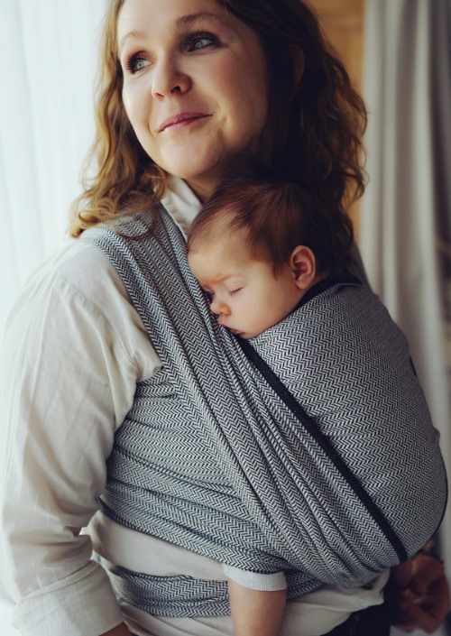 Moeder draagt slapende baby in grijs-wit visgraatpatroon draagdoek Little Frog Zen Path