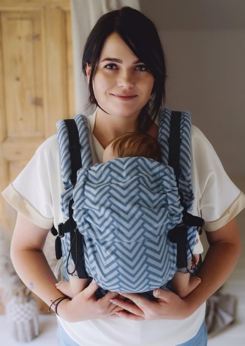 Little Frog Prime Carrier Nordic Miles met blauw chevronpatroon, gedragen met een baby op de buik