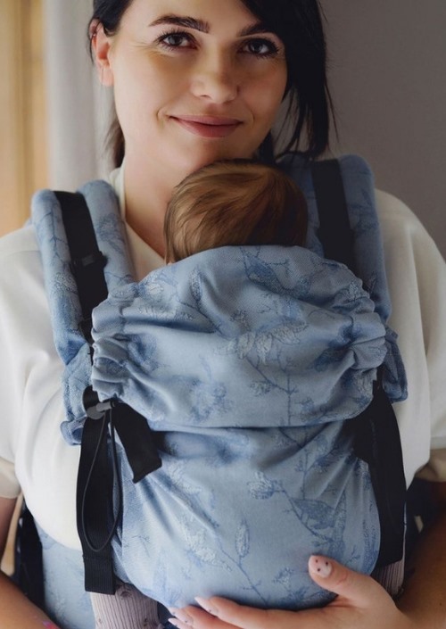 Little Frog Prime Carrier Joy of Life Air in lichtblauw met botanisch patroon, gedragen met baby tegen de borst