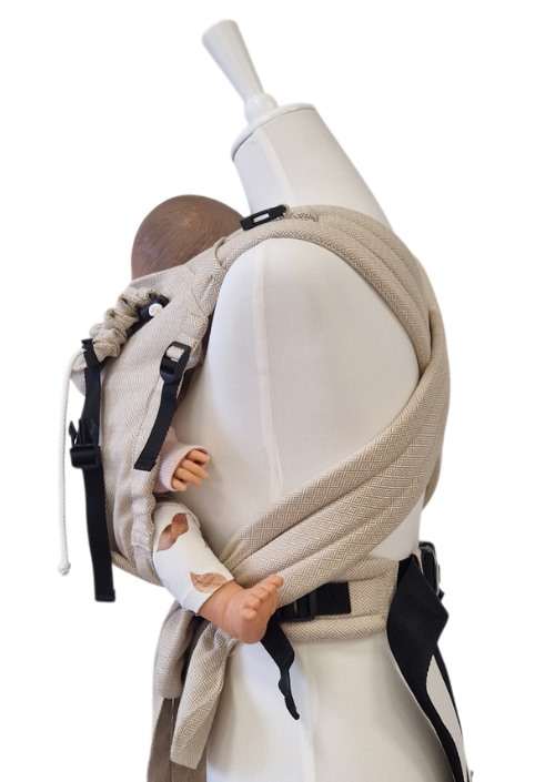 Storchenwiege Talemo Leo Natural draagzak in beige met baby op de rug, zwarte gespen en verstelbare banden