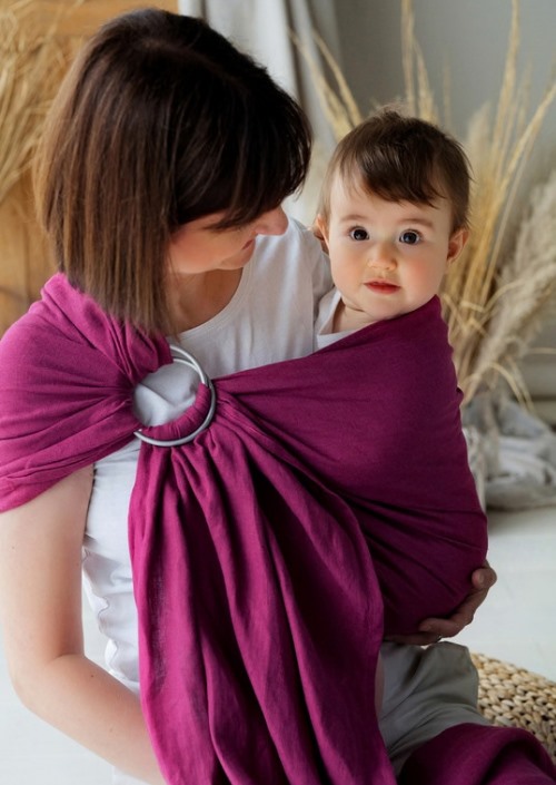 Moeder draagt baby in paarse Little Frog-ringsling met zilverkleurige ringen