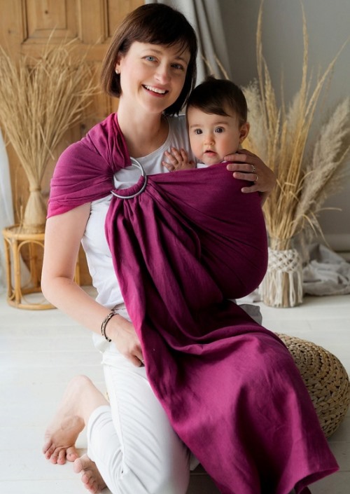 Moeder draagt baby in paarse Little Frog ringsling met zilverkleurige ringen