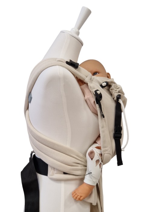 Storchenwiege Talemo Herringbone draagzak in beige, zijaanzicht met baby op een paspop