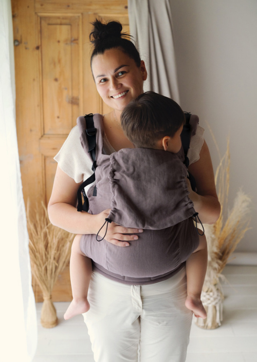 Vooraanzicht van de Little Frog Preschooler Pure Linen draagzak met een groter kindje op de buik.