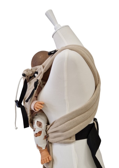Beige Storchenwiege Talemo met baby op de heup, zwarte banden en verstelbare koorden zichtbaar