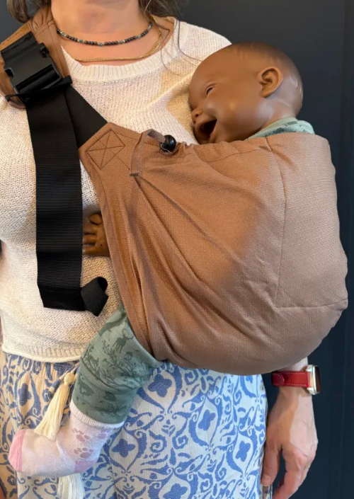 Neko Up & Down Hip Carrier Nomad in warme bruine tinten gedragen op de heup