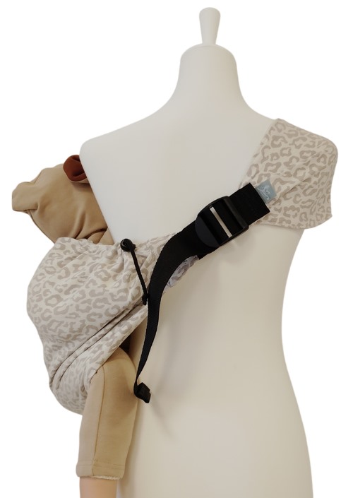 Storchenwiege Hipino Mara met beige luipaardpatroon, zwart verstelbandje en pop met kind op de heup