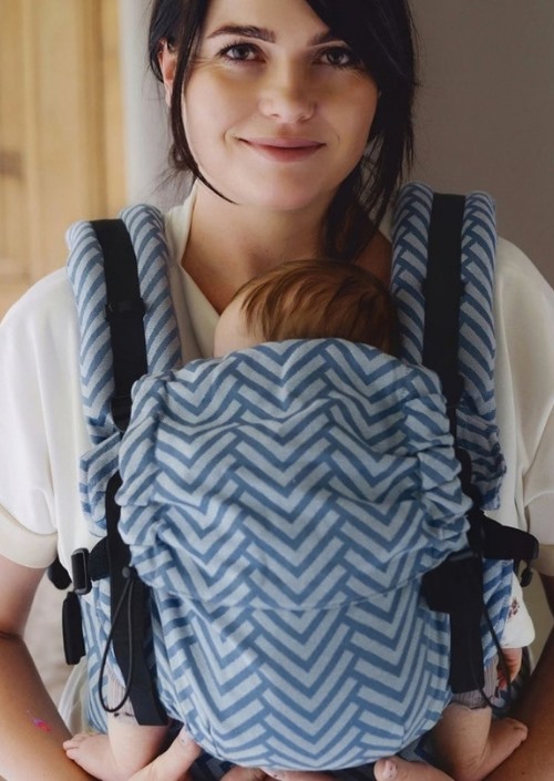 Vrouw draagt een baby in Little Frog Prime Carrier met blauw-wit zigzagpatroon, van voren gezien