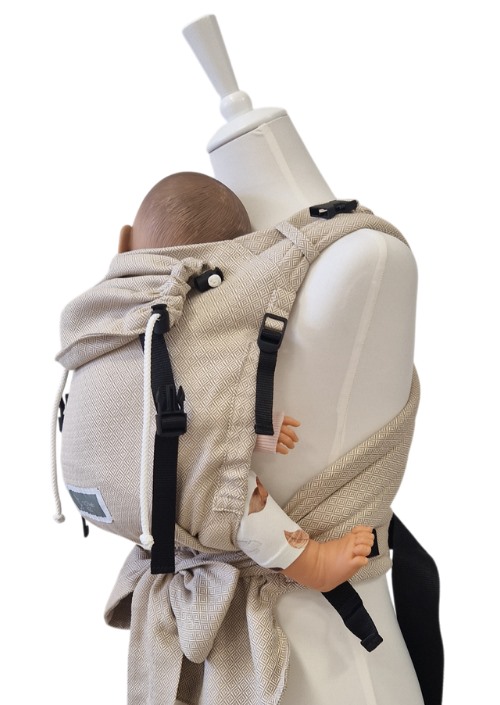 Beige Storchenwiege Talemo met subtiel geometrisch patroon, gedragen op de rug met een baby en zwarte gespen.