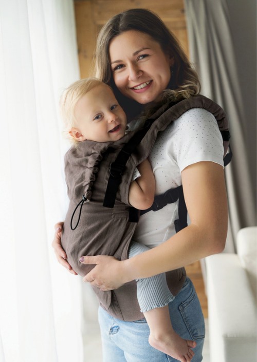 Little Frog Prime Pure Linen Frappe bruine draagzak, frontaanzicht, vrouw draagt baby in huis