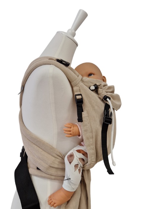 Beige Storchenwiege Talemo draagzak op paspop met baby, zijaanzicht met zwarte gespen en verstelbanden