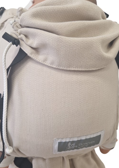 Beige Storchenwiege Talemo met visgraatpatroon, verstelkoord en zwart merklabel op de voorzijde